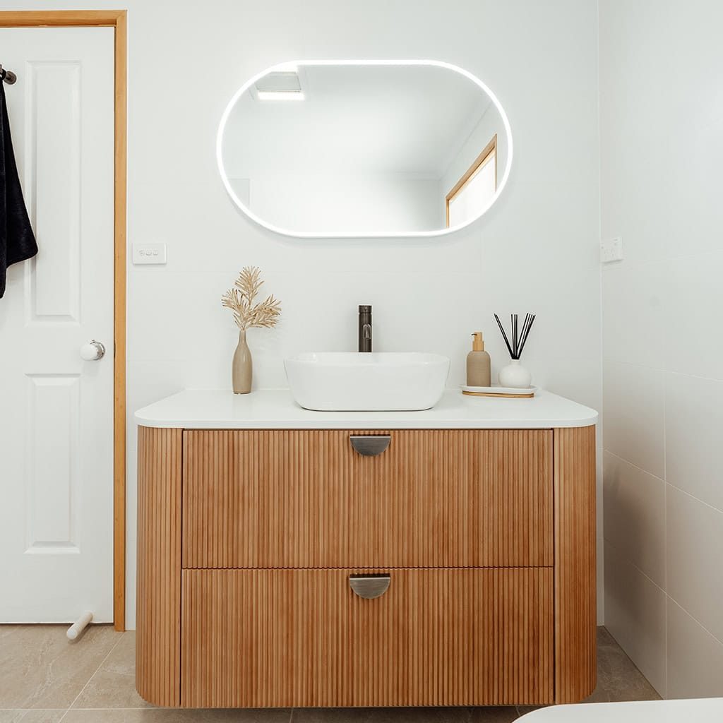 Contemporary bathroom vanity with a stylish mirror and simple decor.